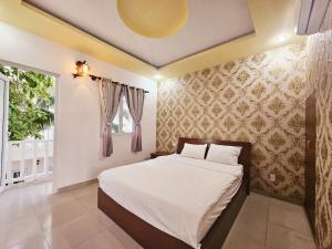 a bedroom with a bed and a window at La Mer Mũi Né Hotel in Ấp Thiện Long