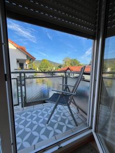 a chair on a balcony with a view of a lake at Wohnung mit Küche Balkon Parkplatz in der Nähe von Heidelberg in Dossenheim +16 photos