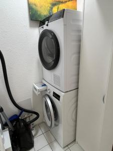 a microwave and a washing machine in a room at Wohnung mit Küche Balkon Parkplatz in der Nähe von Heidelberg in Dossenheim