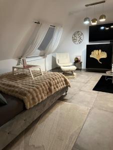 a bedroom with a large bed and a chair at Moderne schicke Dachgeschosswohnung 15 min bis Düsseldorf in Duisburg