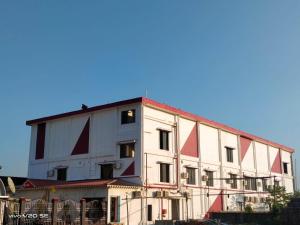 a large white building with red triangles on it at Maa Paradise World in Alīpur Duār