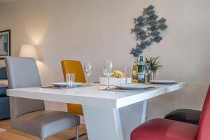 un tavolo bianco con sedie e bicchieri da vino sopra di Ferienwohnung Luv a Gelting