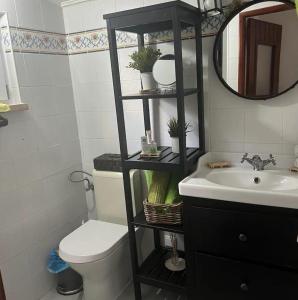 Un baño con inodoro, lavabo y espejo. en Windmill House, en Encarnação 11 fotos más