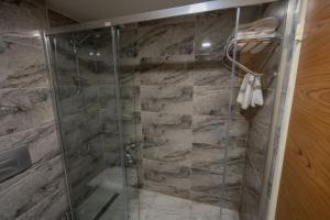 a shower with a glass door in a bathroom at The Green Park Taksim in Istanbul