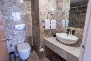 a bathroom with a sink and a toilet at The Green Park Taksim in Istanbul