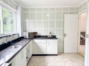 Η κουζίνα ή μικρή κουζίνα στο Conforto e Localização no Coração de POA SK1661