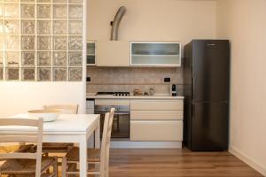 a kitchen with a table and a black refrigerator at LHE Black Rose in Cesena