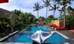 a swimming pool with red chairs and a resort at The Jingga Villas in Nusa Lembongan