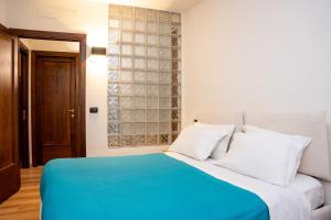 a bedroom with a blue bed with white pillows at LHE Black Rose in Cesena
