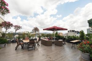 a patio with tables and chairs and an umbrella at The Green Park Taksim in Istanbul