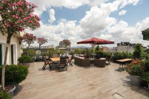 a patio with tables and chairs and an umbrella at The Green Park Taksim in Istanbul