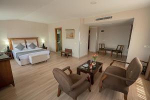 a bedroom with a bed and a living room with chairs at The Green Park Taksim in Istanbul
