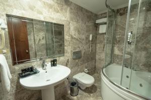 a bathroom with a sink and a toilet and a shower at The Green Park Taksim in Istanbul