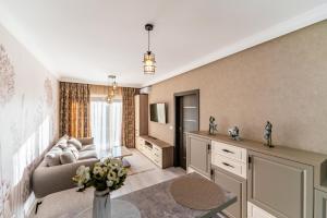 a living room with a couch and a table at Cozy Collection Apartments at Adora Park in Arad
