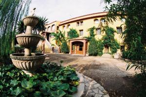 a house with a fountain in front of a yard at Mas La Trampa in La Selva del Camp