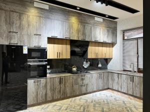 a kitchen with wooden cabinets and a black appliances at Эксклюзивный Дом Самарканда in Samarkand