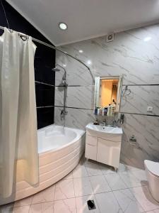 a bathroom with a tub and a sink and a toilet at Эксклюзивный Дом Самарканда in Samarkand