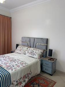 a bedroom with a large bed and a nightstand with a bed sidx sidx sidx at Appartement au centre ville pres de la plage in El Jadida
