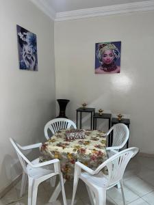 a white dining room with a table and two chairs at Appartement au centre ville pres de la plage in El Jadida