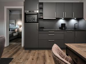 a kitchen with gray cabinets and a wooden floor at Mountain King Chalet in Kitzbühel