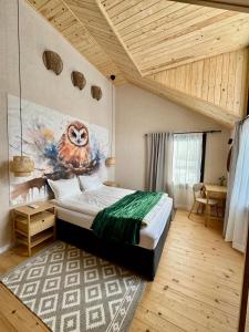 a bedroom with an owl painting on the wall at High Five Villas in Pamporovo