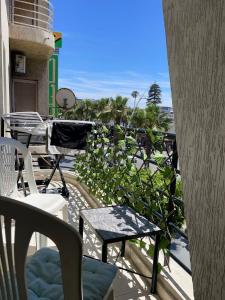 a balcony with chairs and tables and a view of the ocean at Appartement au centre ville pres de la plage in El Jadida