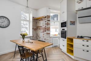 ヘルシンキにあるSTAY Kamppi Seaside Apartmentの木製テーブルと時計付きのキッチン