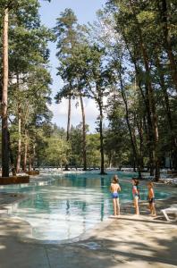 three children standing in the water at a swimming pool at Парк-Готель "Золотий Пляж" in Orlovshchina