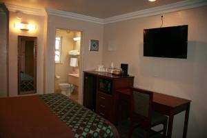 ein Hotelzimmer mit einem Bett und einem Flachbild-TV in der Unterkunft Civic Center Lodge / Lake Merritt BART in Oakland