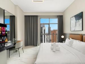 a white bedroom with a large bed and a desk at Downtown Panoramic View in Dubai +40 photos