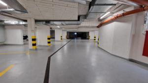 an empty parking garage with yellow and black poles at InPoint Apartments G15 near Old Town & Kazimierz District & Optional Paid Parking in Krakow