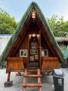 Santo NiñoSand Castles Beachfront Resort的茅草屋顶和楼梯的小房子