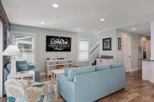 een woonkamer met een blauwe bank en stoelen bij NH387 Haven on the Banks in Nags Head