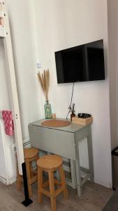una scrivania con una televisione su un muro con due sgabelli di Marbeuf - Lao Immo a Grenoble
