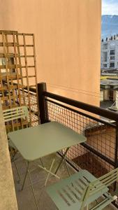 un tavolo verde e sedie sul balcone di Marbeuf - Lao Immo a Grenoble