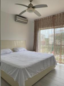 a bedroom with a bed with a ceiling fan and a window at Luxury sea Cadaques Caribe in Bayahibe