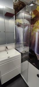 a white bathroom with a shower and a sink at Ferienwohnung Eisgeliebt in Schweinfurt +3 photos