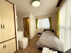 a small bedroom with a bed and a window at 2-6大通駅まで地下鉄で4駅の場所で美室のリフォーム済みアパートメント in Sapporo
