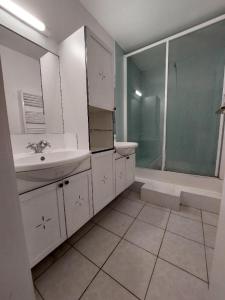 a white bathroom with a sink and a shower at Maison avec terrasse Bordeaux Chartrons in Bordeaux