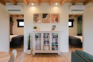 a living room with a white cabinet and two beds at Vakantiehuis Blok 25 in Zierikzee