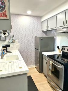 a kitchen with a sink and a refrigerator at SoCozy Condo in Austin