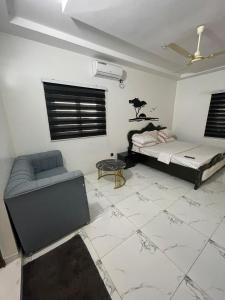 a living room with a bed and a couch at RESIDENCE ORELIO Agoè in Agbéli