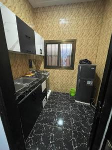 a kitchen with a black counter top and a refrigerator at RESIDENCE ORELIO Agoè in Agbéli