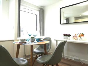 Una mesa de comedor con sillas y un espejo. en Luxurious Home Tottenham Court Road CharingCross Leicester Square, en Londres