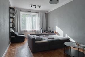 una sala de estar con un sofá y una mesa en Cozy apartment near the embankment and the Old Town and free parking in front of the apartment windows, en Riga