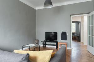 Una sala de estar con un sofá y un televisor. en Cozy apartment near the embankment and the Old Town and free parking in front of the apartment windows, en Riga