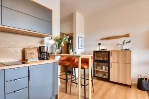 a kitchen with a counter and a bar with stools at Ferienwohnung Grasmücke 09 im Wreecher Idyll Rügen by ruyastay in Putbus