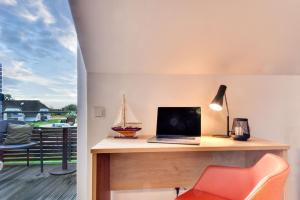 a desk with a laptop and a toy boat on a balcony at Ferienwohnung Grasmücke 09 im Wreecher Idyll Rügen by ruyastay in Putbus