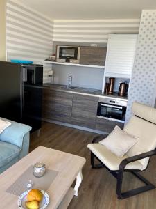 une cuisine et un salon avec une table et un canapé dans l'établissement Ferienresidenz Haus Vogelflug Fehmarn-Ostseeferien Strandresidenz Vogelflug 141 App 4 Meerblick, à Fehmarn