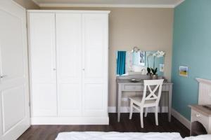 - une chambre avec un bureau, une chaise et un lavabo dans l'établissement Ferienresidenz Haus Vogelflug Fehmarn-Ostseeferien Strandresidenz Vogelflug 141 App 4 Meerblick, à Fehmarn
